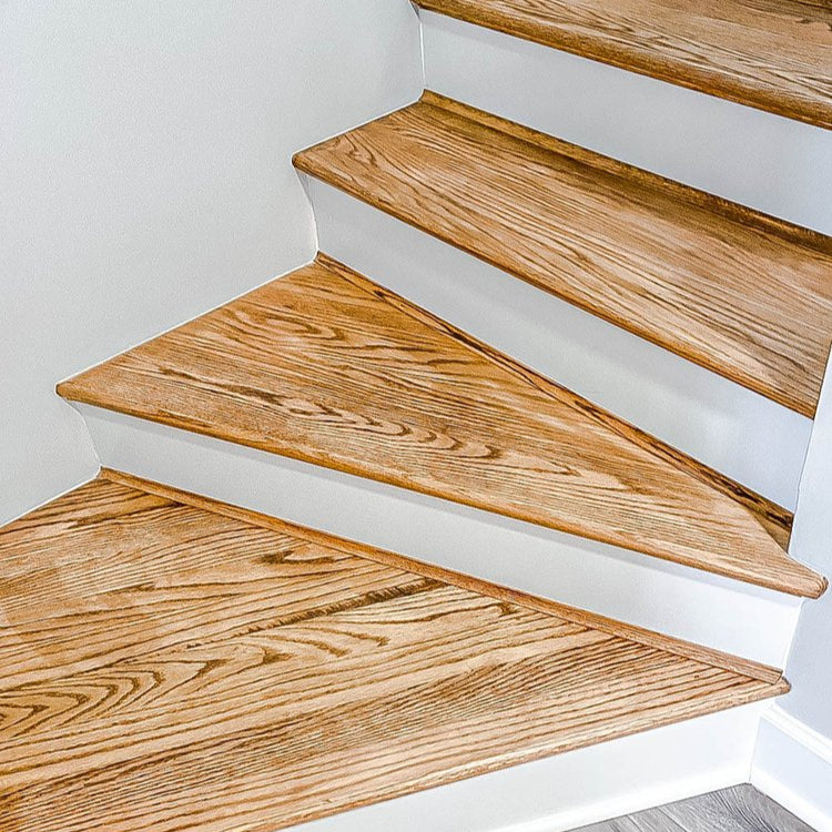 Wooden staircase with white risers on a light gray floor.