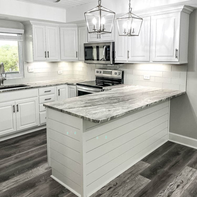Modern kitchen with white cabinets, marble countertop, and stainless steel appliances.