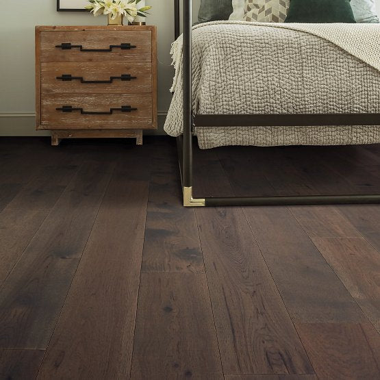This is a room scene photo of the imperial pecan in the color origin. There is a metal bedframe with a light wood night stand