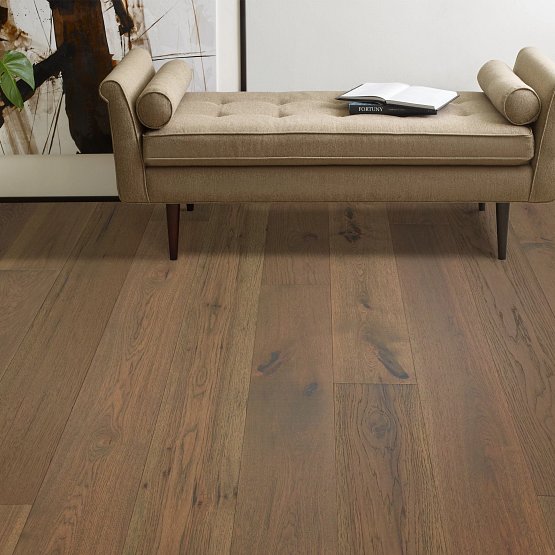 This is a room scene of imperial pecan flooring in the color hazel. There is a tan bench for seating with books laying on top