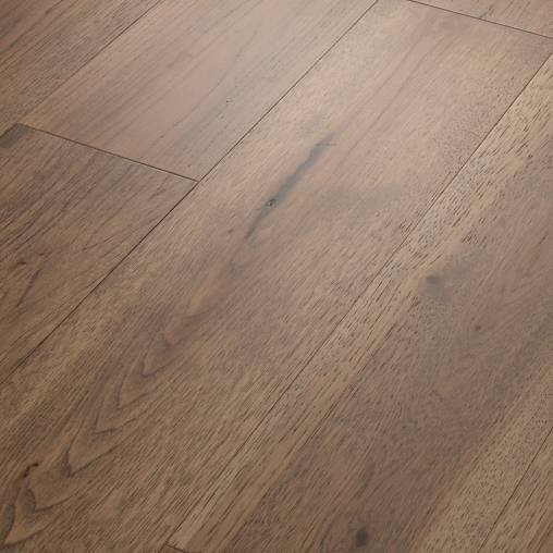 This is a picture of an antique, hardwood floor. The floor is made of wide planks with a smooth finish. The color is a medium brown with a slight reddish tint.
