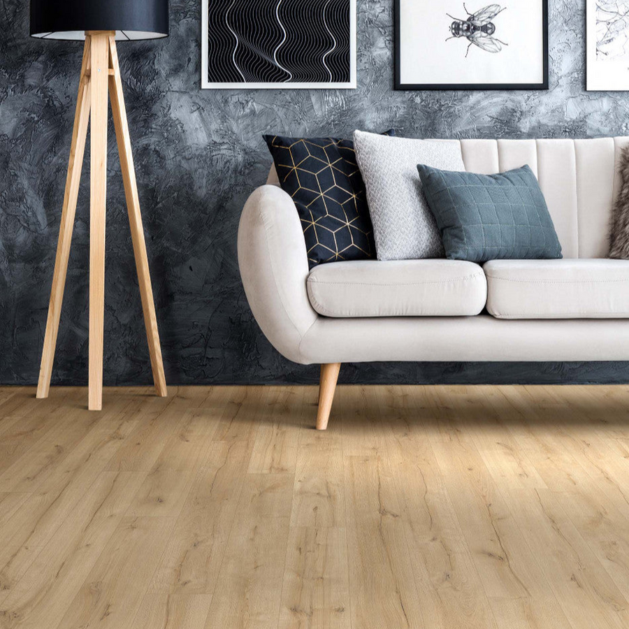 This is a close up picture of a white couch with vinyl plank flooring and a dark grey wall color