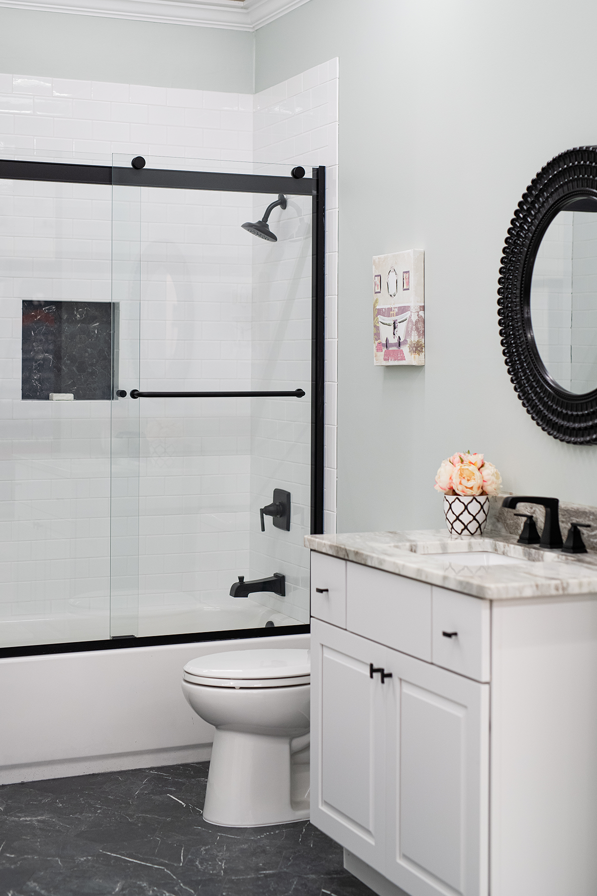 black and white tile shower vignette with black tile flooring a white subway