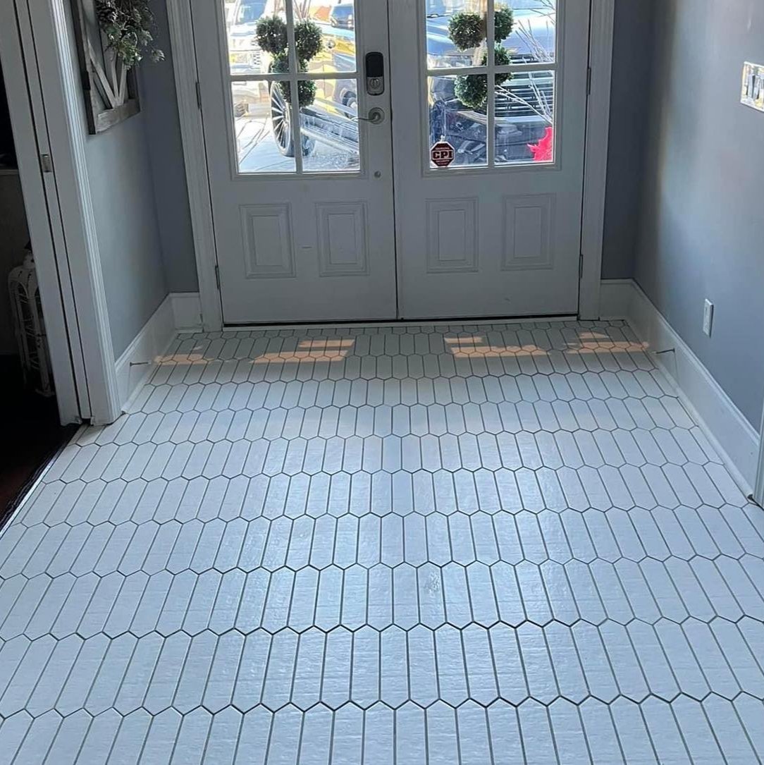 an entry way with white picket tiles