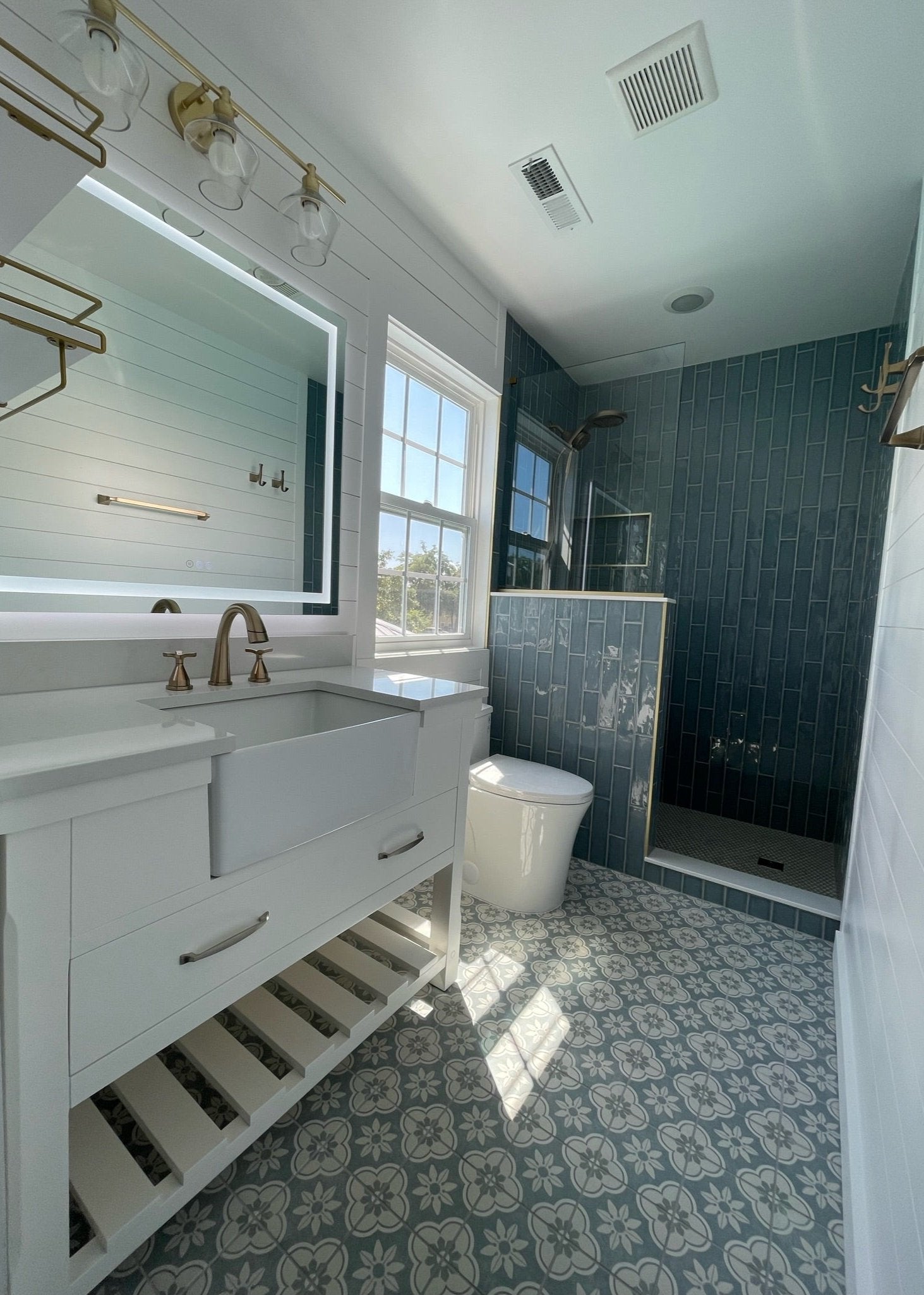 a bathroom remodel with blue tile on the floor and in the shower