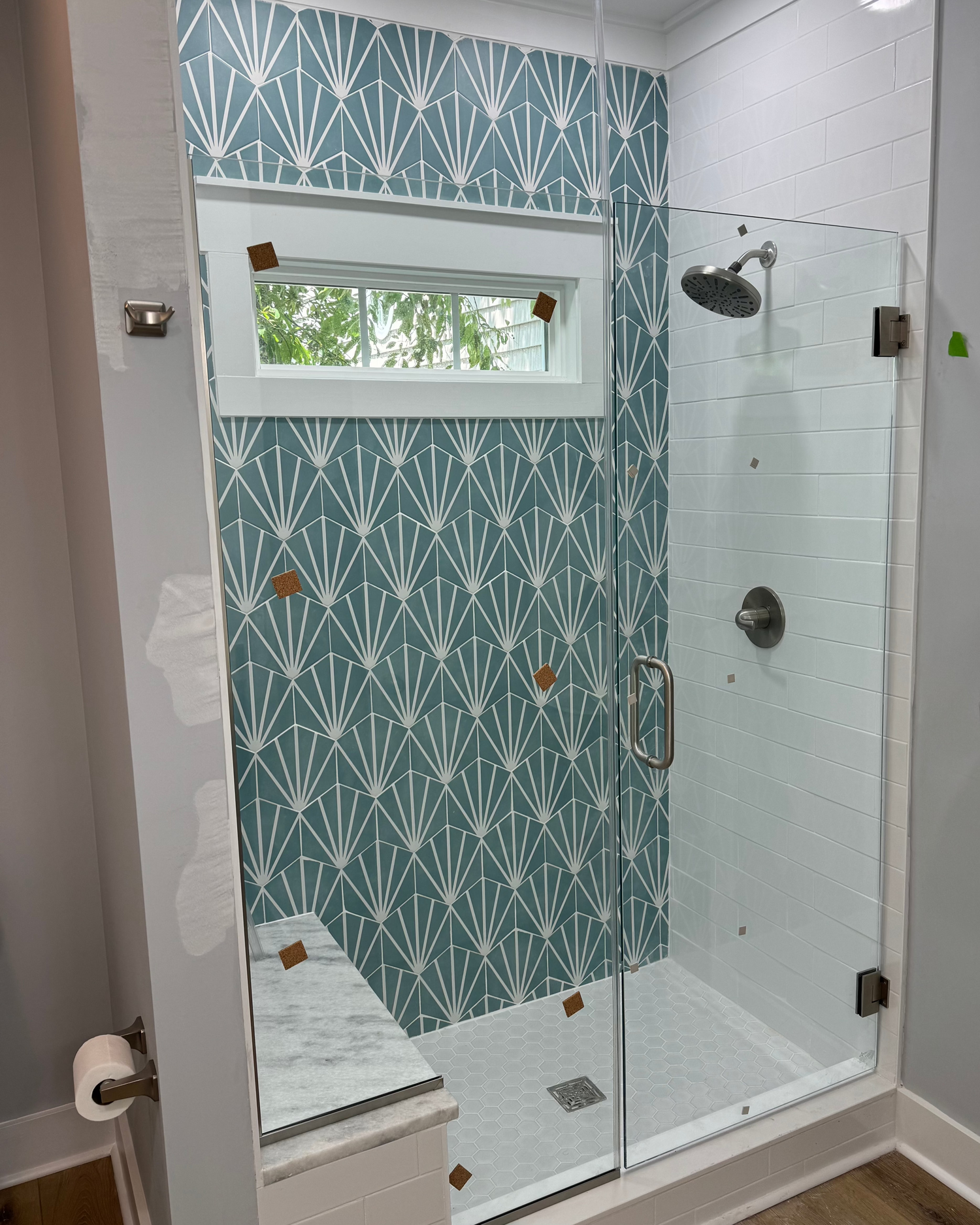 a newly installed shower with blue hex wall tile