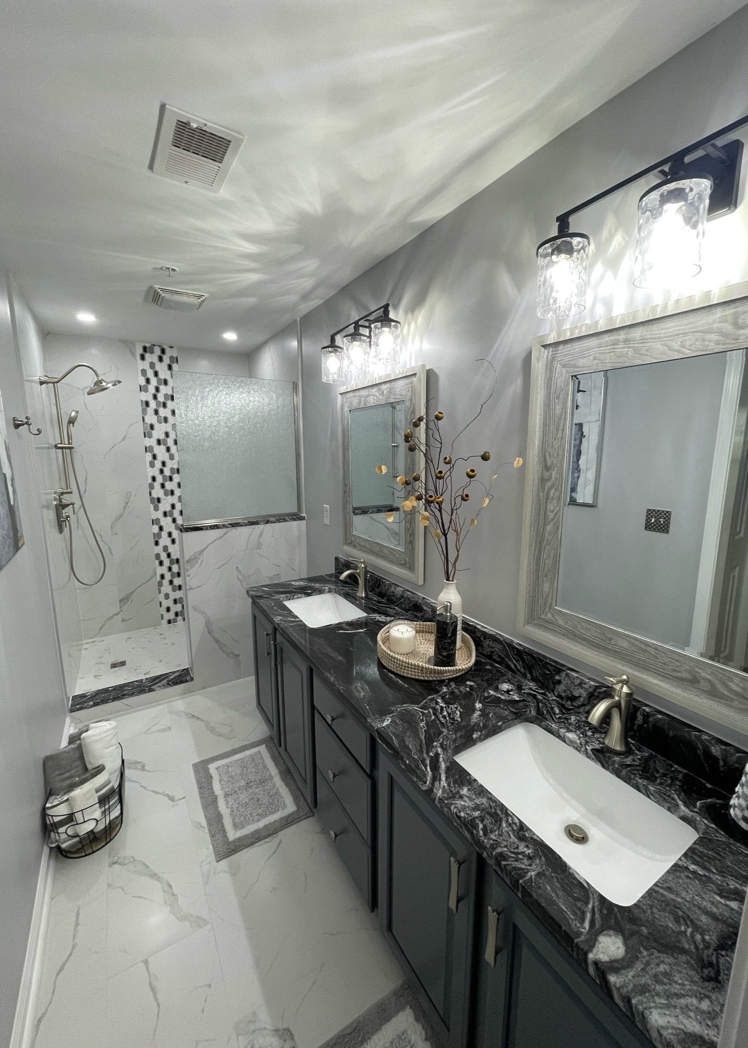 A bathroom remodel with tile flooring and a black and white tile shower