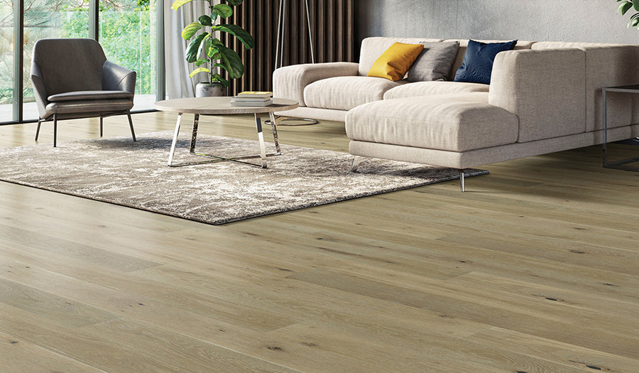 This is a living room scene with a white couch and multicolored rug. The hardwood floor is palladio in the color barley