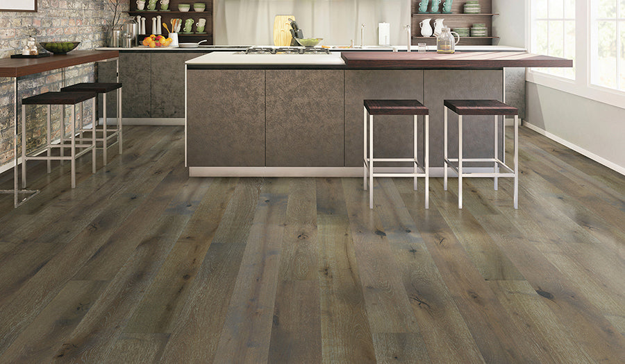 This is a room scene of a kitchen with the hardwood flooring palladio in the color bourbon. This is a modern looking kiutchen with dark cabinets and furniture