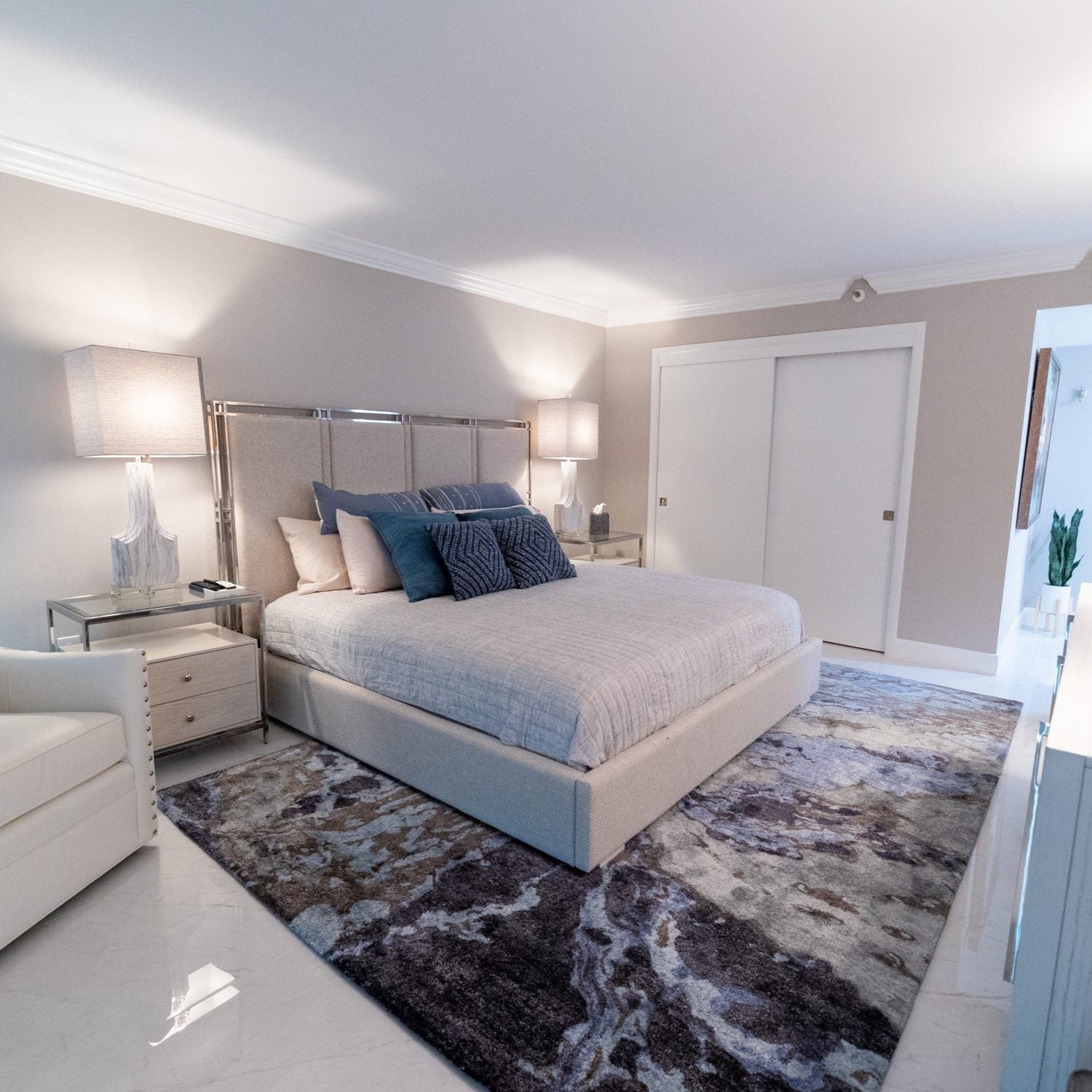 bedroom scene with blue marbled carpet and a beige bed frame