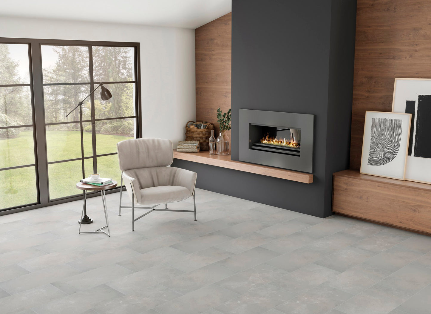 This is a room scene of a living room with a black fireplace and cream chair. The floor tile is st croix in the color pewter