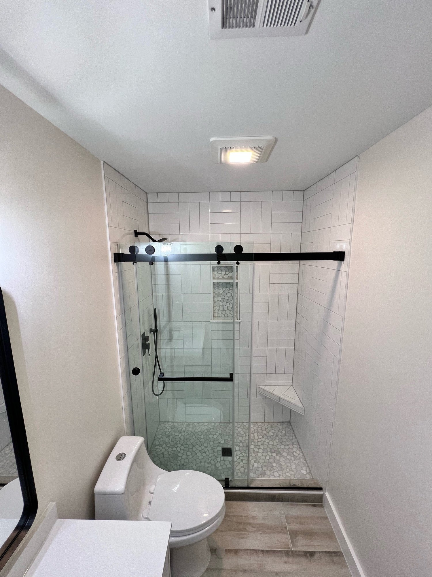 a bathroom with white subway tile and black trim