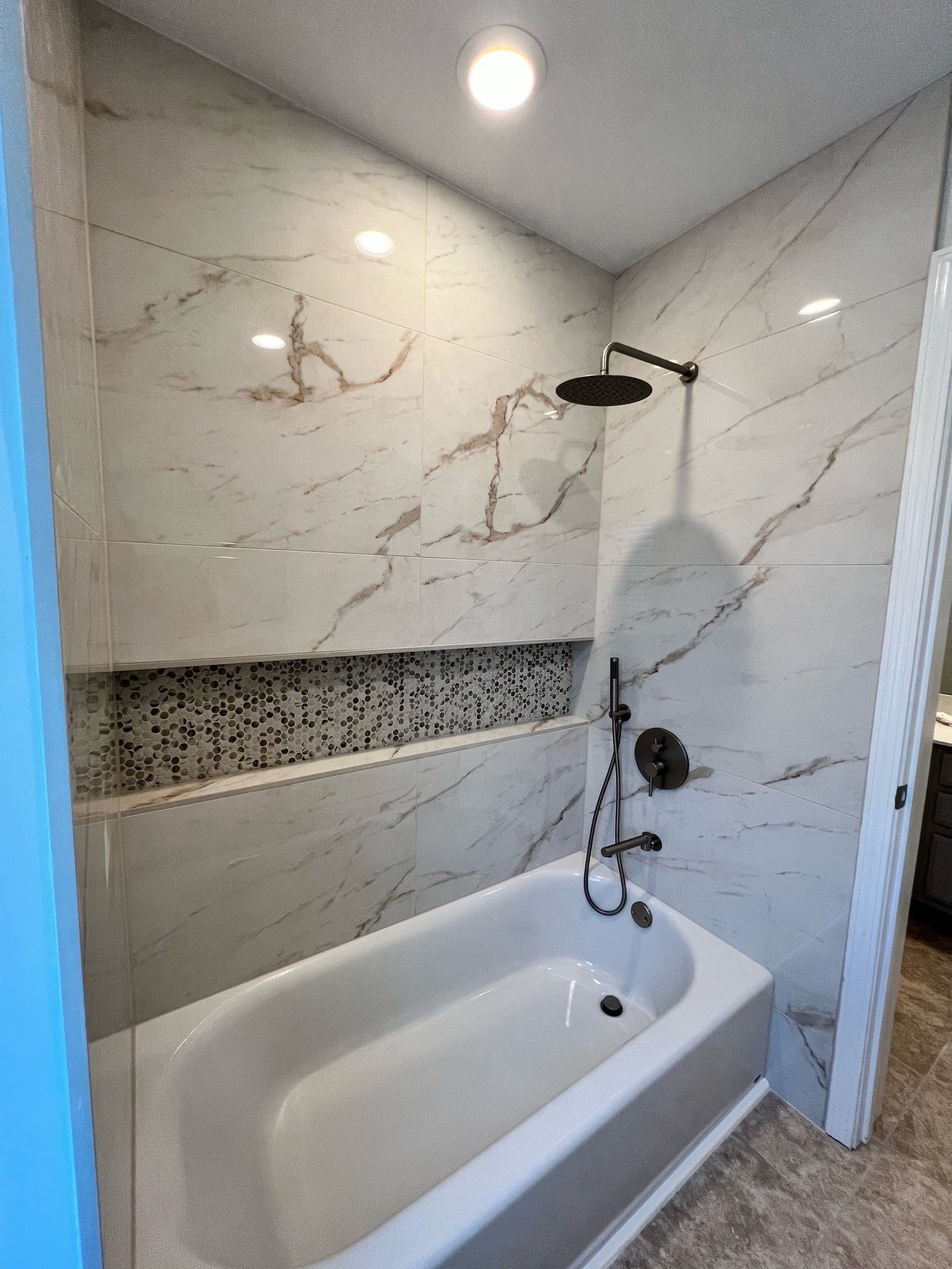 Marble tile shower with penny niche