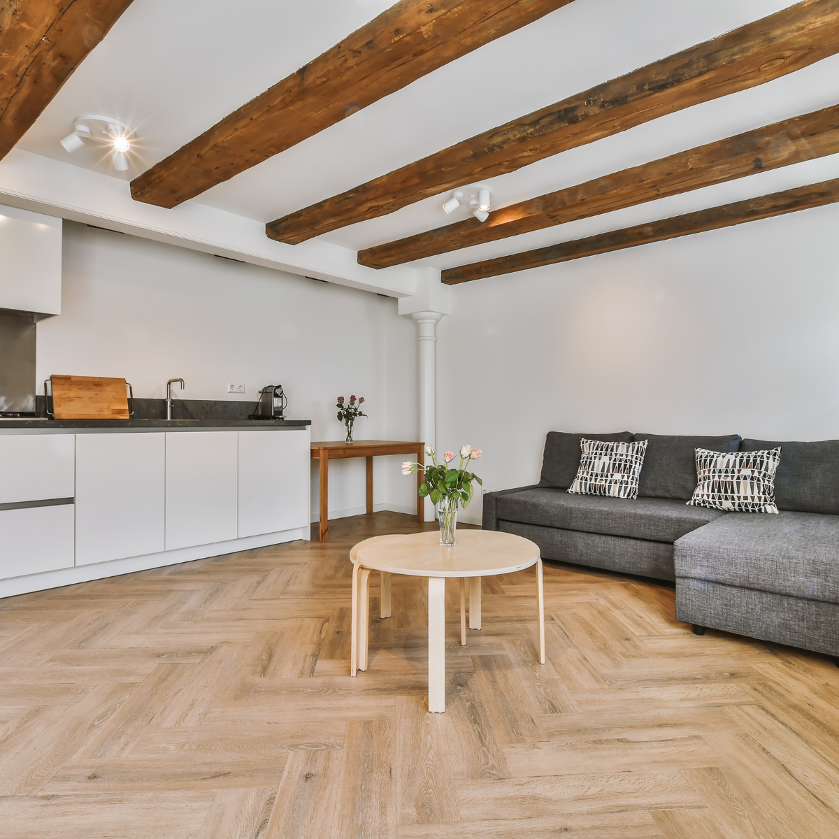 open concept with grey couch and chevron pattern flooring