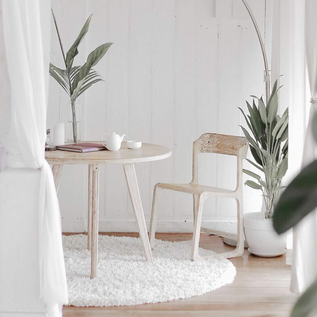 Living room scene with white curtains and light colored wood furniture