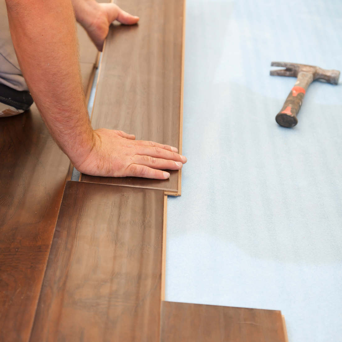 man laying laminate flooring