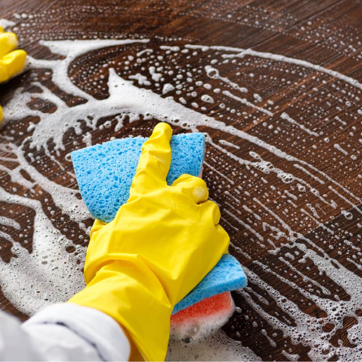 a person cleaning floors wearing yellow gloves