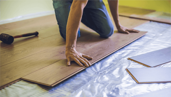 man installing luxury vinyl plank flooring