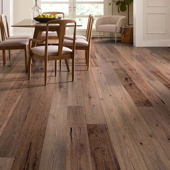 This picture shows a close-up of hardwood flooring. The planks are a light brown color with darker streaks.