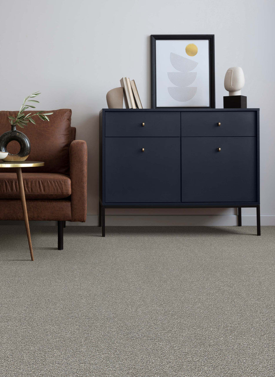 Autumn glow carpet by dreamweaver in a living room setting with a black dresser and a brown couch