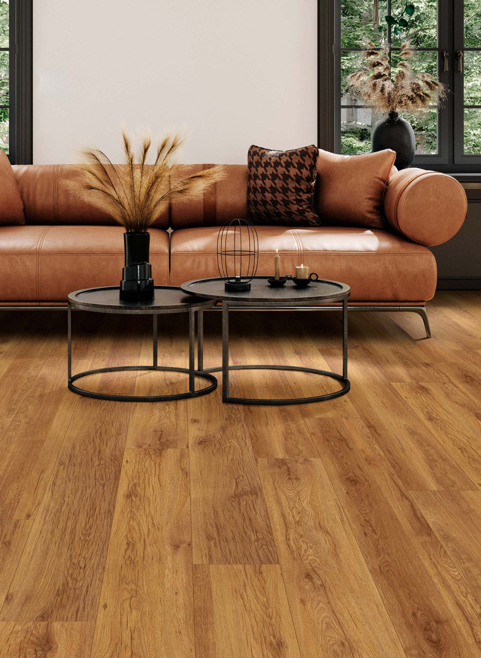 This is a living room scene with a brown leather couch paired with dark wood coffee table. The floor is riverwood in the color sumatra