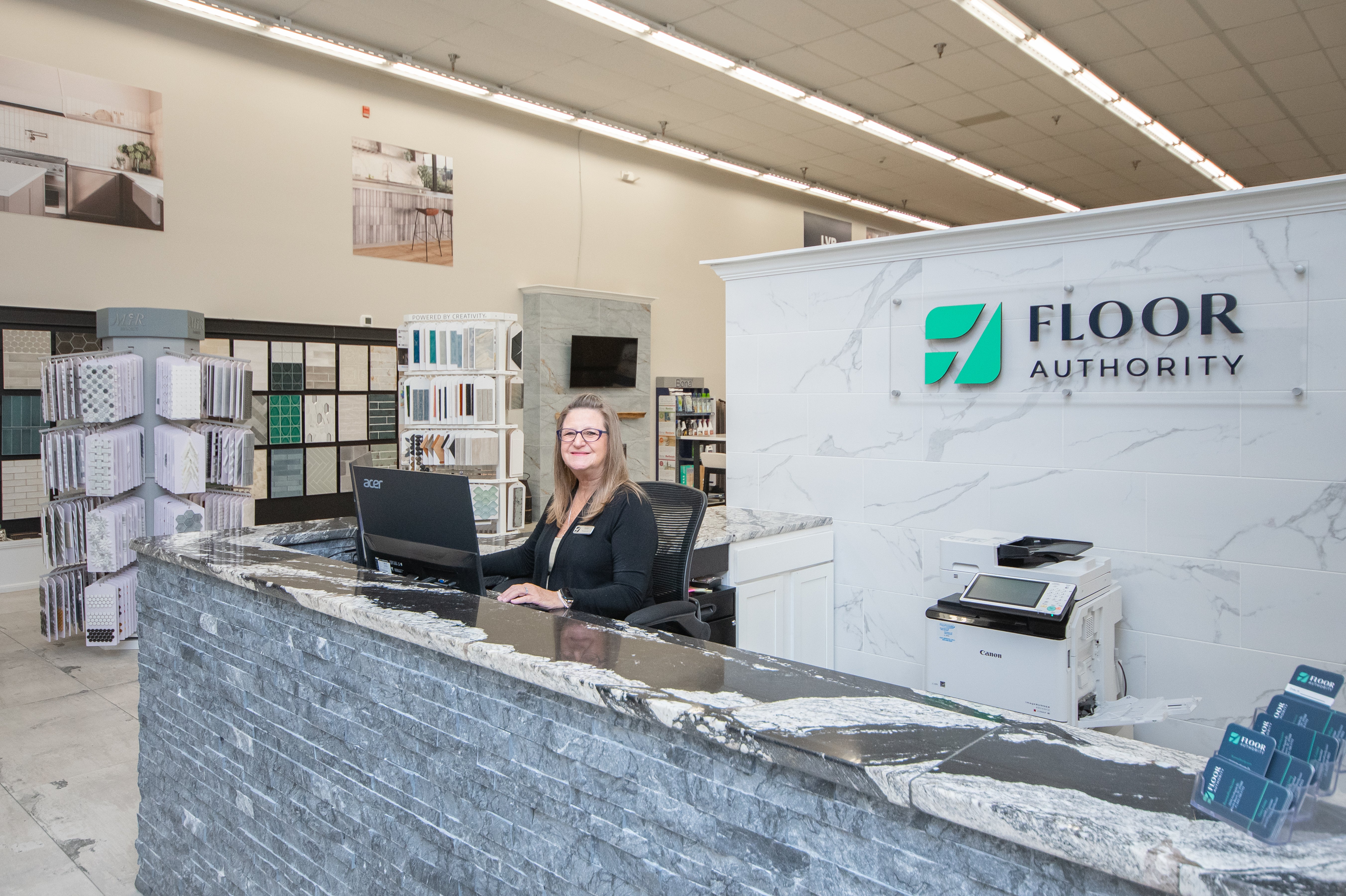 Person behind a counter in a store with 'Floor Authority' branding.