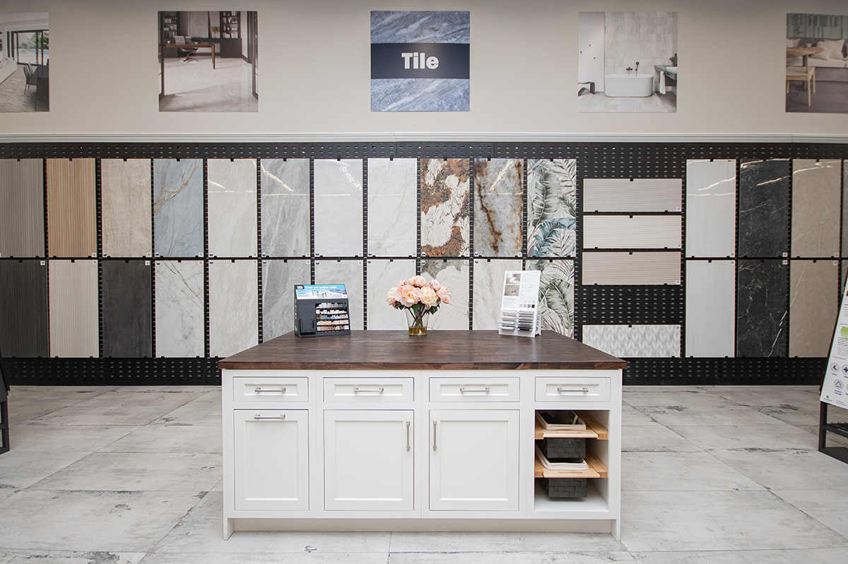 Display of tile samples and a kitchen island in a showroom setting.