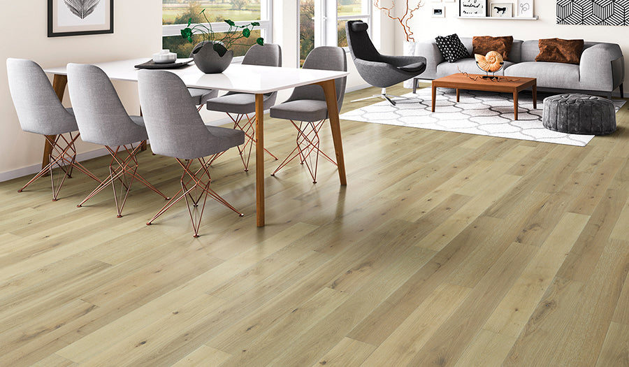 This is a room scene of palladio hardwood in the color white wash. There are grey dining room chairs paired with a white table and a grey couch and espresso coffee table.