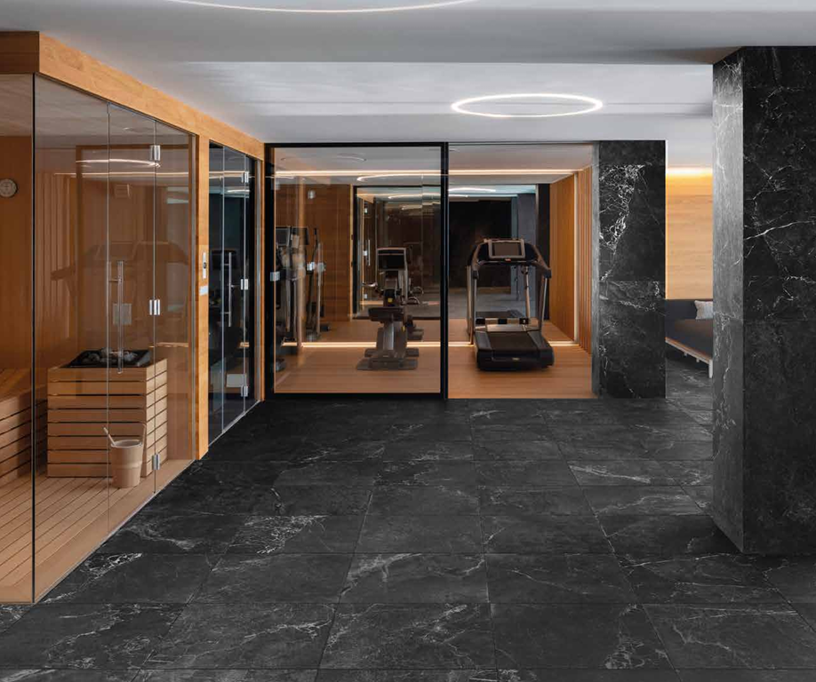 Thisis a room scene of a home gym with the tile marmi imperial in the color zenobia. There is a sauna to the side and a treadmill in front of a mirror