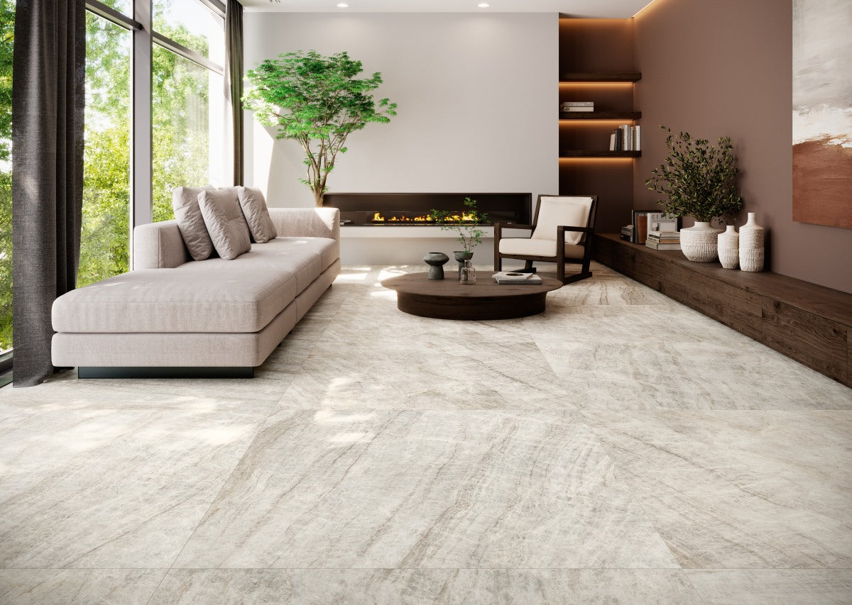 This is a room scene of a living room with a fire place. Paired with a linen couch and espresso wood furniture. The tile flooring is taj mahal