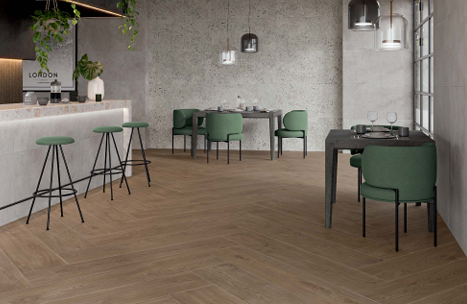 This is a room scene of a bar area with green stools and tymber nogal wood looking tile.