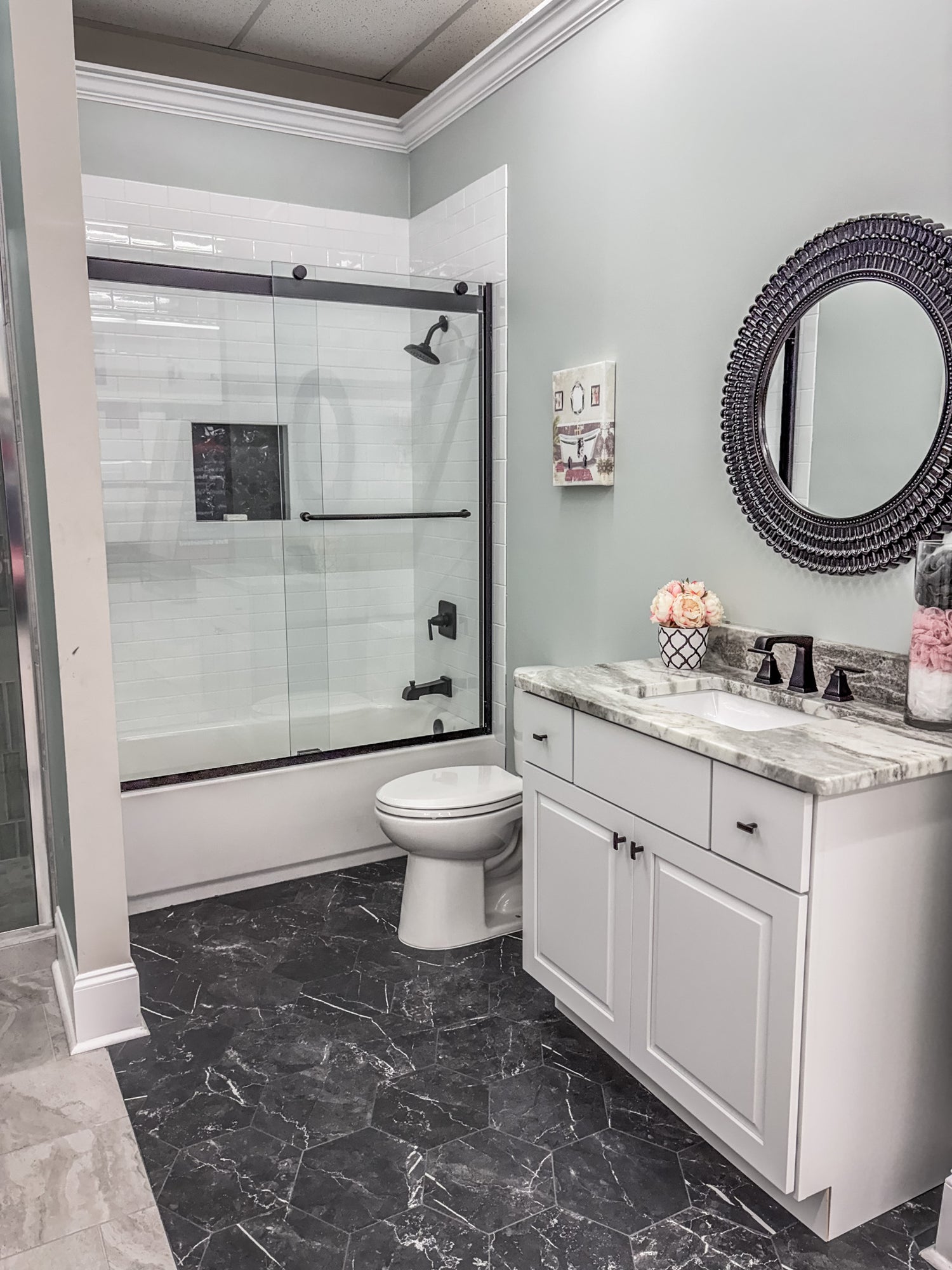 bathroom vignette with white soho subway tile and black hexagon flooring tile